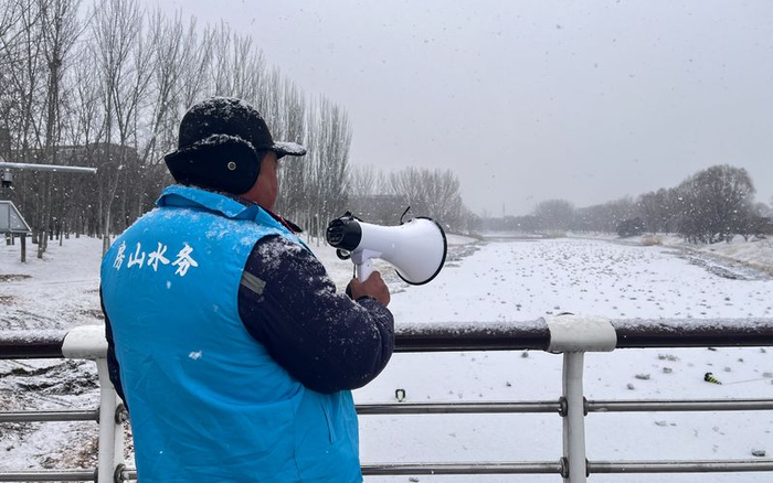 1月17日，房山区水务部门工作人员在长阳公园内巡护，劝阻市民上冰。新京报记者 陈璐 摄