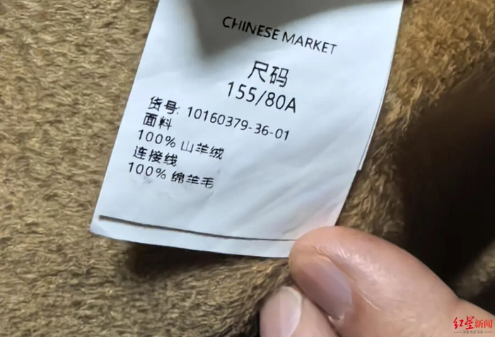 ▲大衣标签显示，面料为100%山羊绒