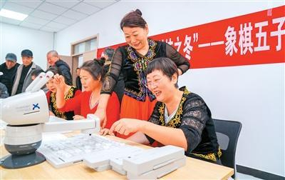 新疆维吾尔自治区乌苏市文林路社区，居民与AI下棋机器人对弈。李仁锡摄（人民视觉）