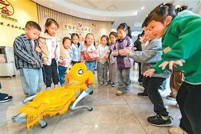 浙江省金华经济开发区马鞍山社区活动室里，小朋友与智能机器人互动。胡肖飞摄（人民视觉）