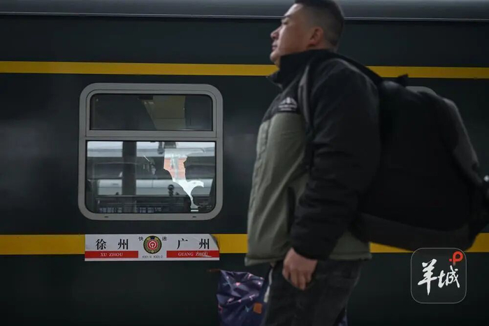 乘客在广州火车站乘坐K303次从广州开往徐州的绿皮火车