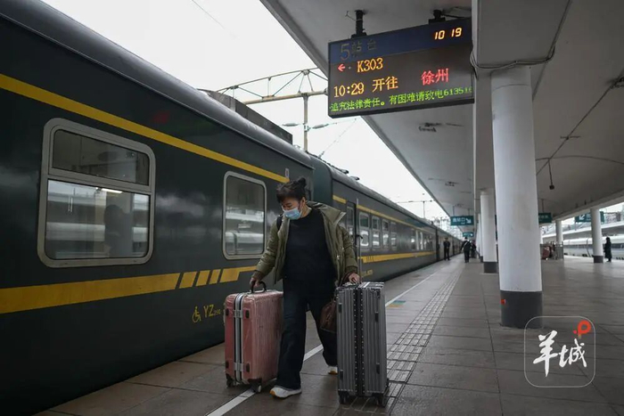 乘客在广州火车站乘坐K303次从广州开往徐州的绿皮火车