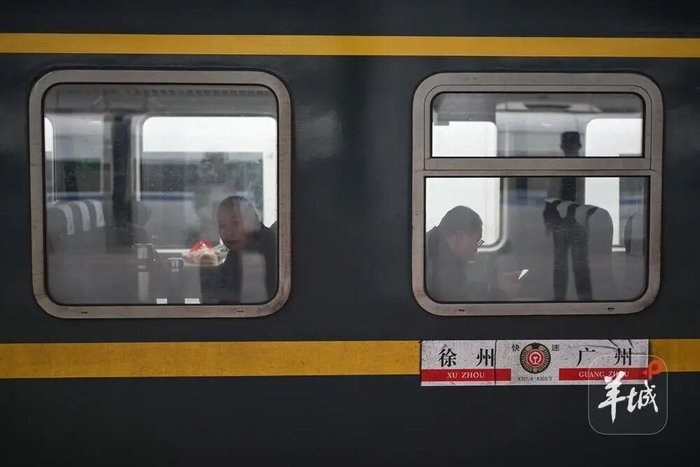 乘客在广州火车站乘坐K303次从广州开往徐州的绿皮火车