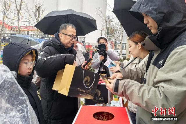 1月25日，合肥市民拿着“年轮”演唱会在兑换消费券。中新社记者 张强 摄