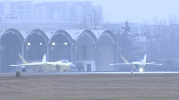 此次报道的配图展示了底漆状态和涂装状态下的多架歼-20A，展现了批产交付工作的成效