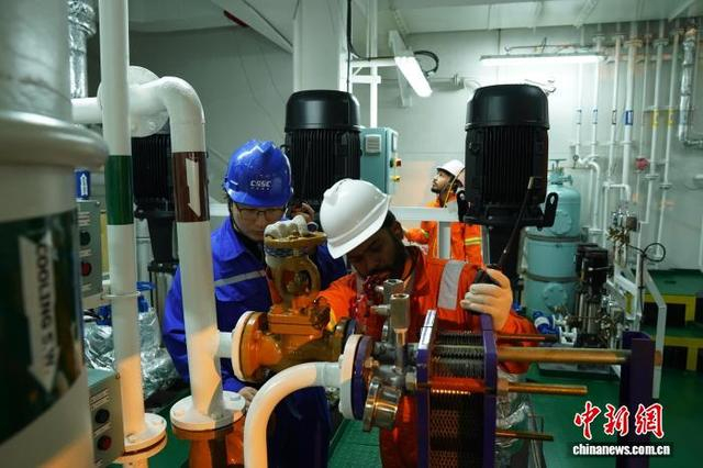 图为工程师对成品油轮机舱内的主机设备进行检测。王继军 摄