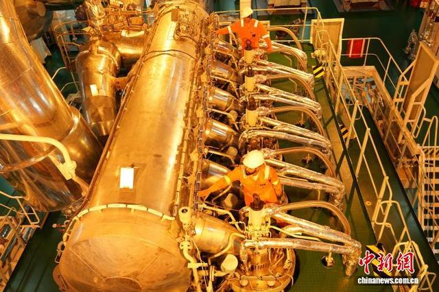 图为工程师对成品油轮机舱内的主机设备进行检测。王继军 摄