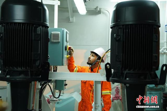图为工程师对成品油轮机舱内的主机设备进行检测。王继军 摄