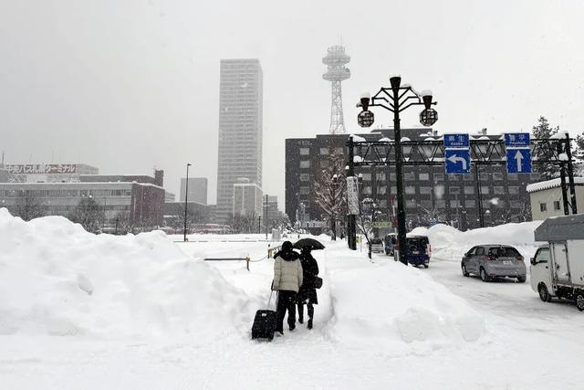 当地时间2026年1月26日，日本北海道札幌，人们冒雪行走。视觉中国 图