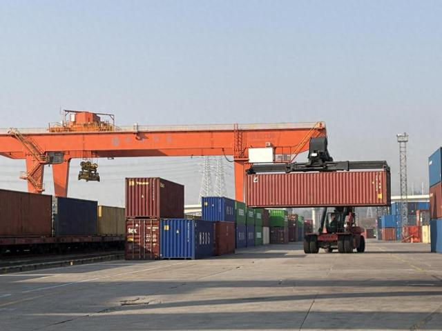 图为浙江义乌西铁路货场内，正面起重机在搬运码放集装箱。新华社记者魏一骏 摄