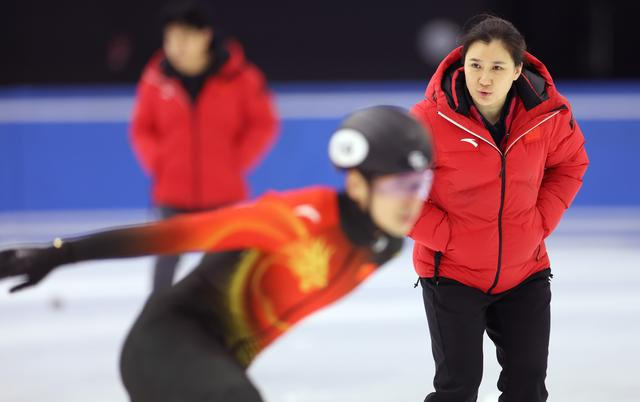 ↑ 中国短道速滑队教练张晶（右）在训练中指导队员。 新华社记者 李明 摄