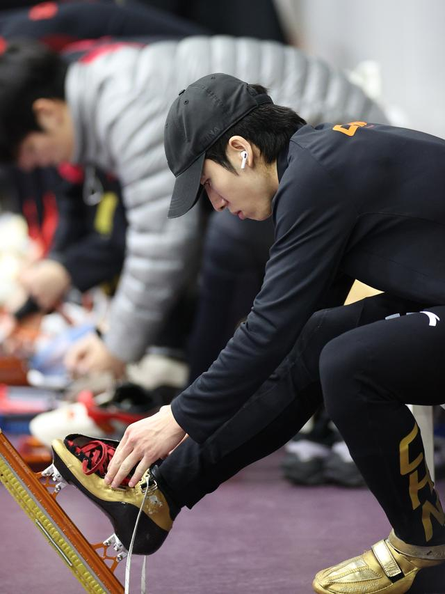 ↑ 中国短道速滑队选手林孝埈在训练前穿上冰刀鞋。 新华社记者 张晨 摄