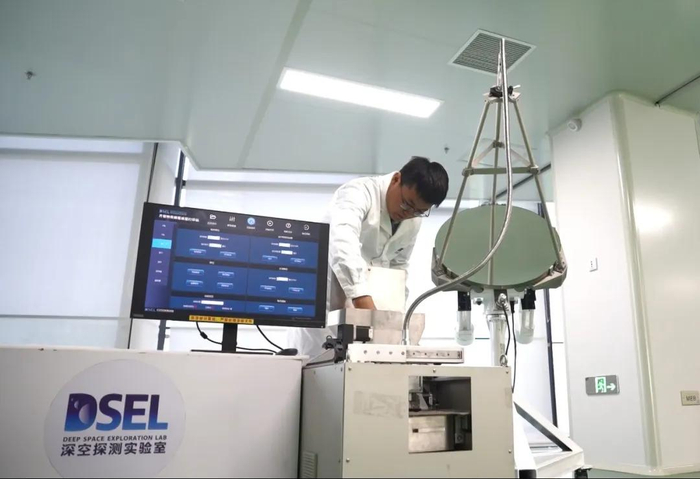 工作人员正在调试月壤打砖机设备。图片来源：深空探测实验室