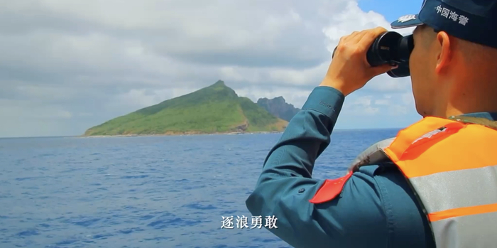 中国海警执法员与钓鱼岛“同框”，手臂上鲜艳的国旗臂章与钓鱼岛的海天美景相映成辉。图片来源：环球网