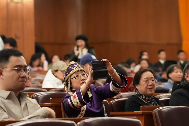 2025年，第21届北京新春音乐会现场，身着民族盛装的观众在人民大会堂拍照留念。北京日报客户端记者 方非摄