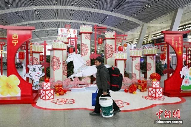 2月2日，旅客从西宁火车站装扮的马年氛围装饰区前走过。 马铭言 摄