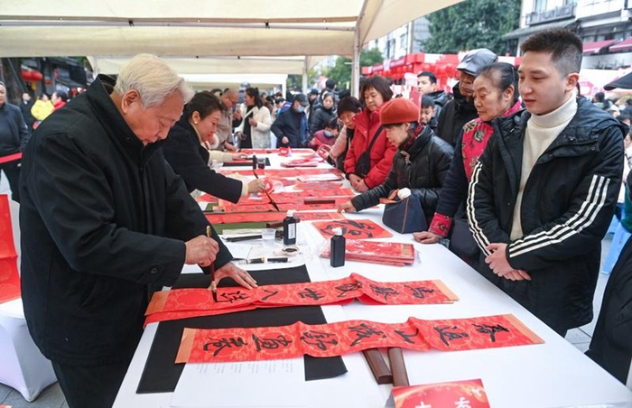 书法爱好者挥毫泼墨为市民游客写春联、送“福”字。重庆市卫健委供图