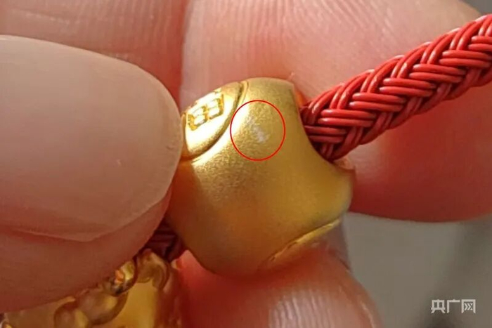 照片显示，挂坠刮花位置出现白色痕迹（受访者供图