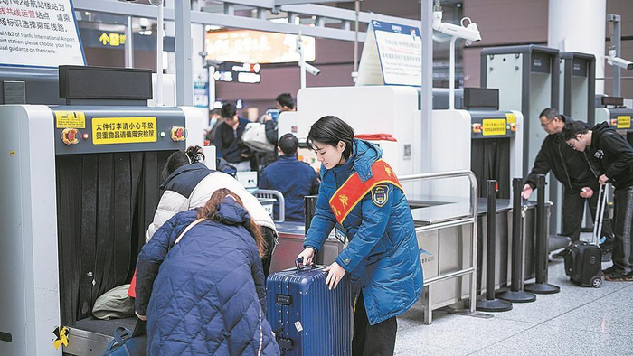     地铁志愿者帮乘客提行李。