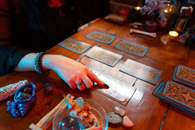 占卜师在木桌上阅读塔罗牌