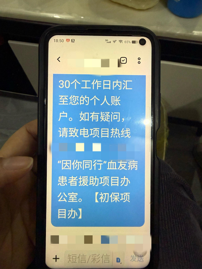 一位患者手机里的短信，显示“因你同行”项目申请成功。新京报记者 黄依琳 摄 
