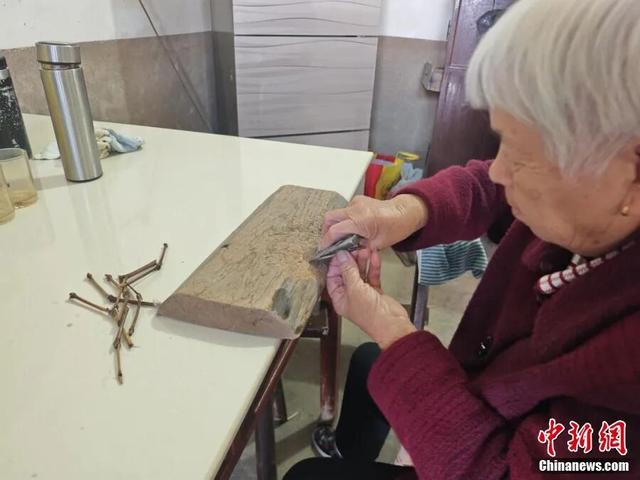 戴美霞正在制作“鱼卡”。 熊锦阳 摄