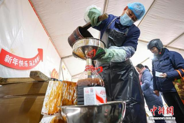 2月7日，江苏镇江，老字号企业设立的酱油供应点工作人员为市民打酱油。中新社记者 泱波 摄 