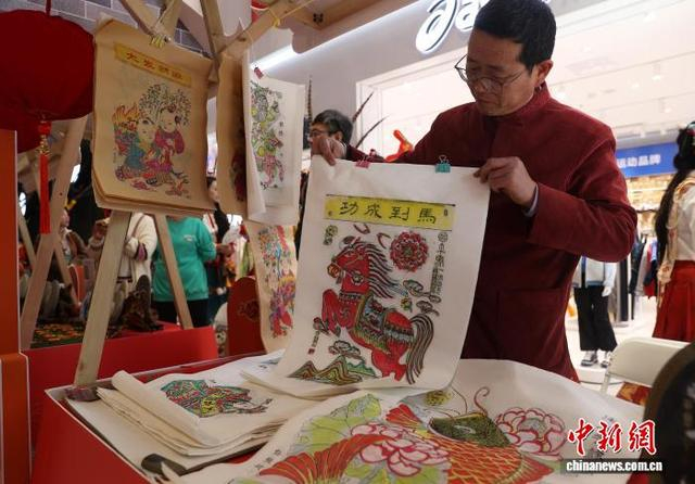 图为宁夏非物质文化遗产保护项目六盘山木板年画代表性传承人任振斌展示马年年画。中新社记者 于晶 摄