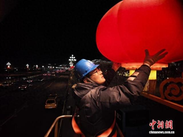 2月6日晚，国网北京电力城市照明管理中心工作人员在西长安街调试大红灯笼。魏晓彬 摄