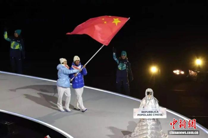 黑龙江速度滑冰运动员宁忠岩携手短道速滑运动员张楚桐共同高举五星红旗引领队伍入场。黑龙江省体育局 供图