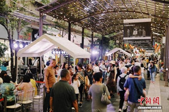 夜晚，云南省昆明市南强街区人头攒动，市民、游客在灯火辉煌的街区内品尝美食、漫步。五华区委宣传部 供图