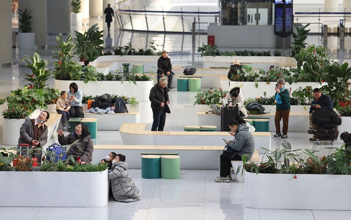 2月8日，北京通州站休息区内，旅客们坐着候车。新京报记者 王贵彬 摄