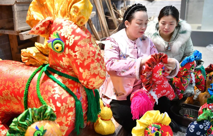 1月22日，河南駐馬店市非遺香包制作技藝傳承人王彩紅（左）趕制新春特色香包。新華社發(fā)（弓華靜攝）