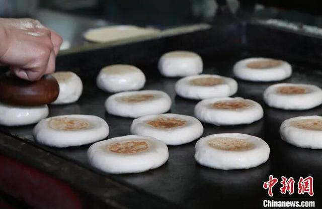 图为河北省保定市徐水区一店家正在制作驴火，打火烧前需要先烙再烤。 中新社发 雷永怀 摄