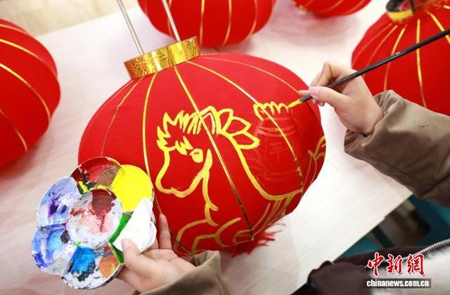 图为农民画爱好者在灯笼上绘福马。龚普康 摄
