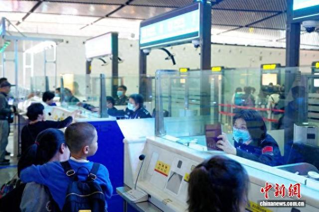 图为南宁出入境边防检查站移民管理警察在南宁口岸对出境旅客开展边防检查。梁箫 摄