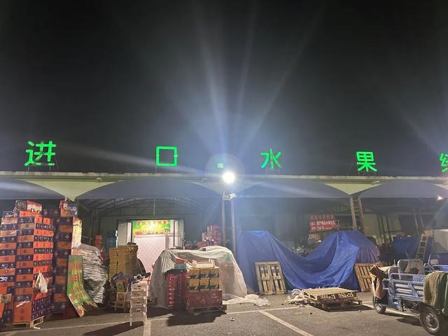 晚上10点多，正在休整的水果批发商户门口堆满即将出货的果品。图源：农视网记者赵宁宁拍摄
