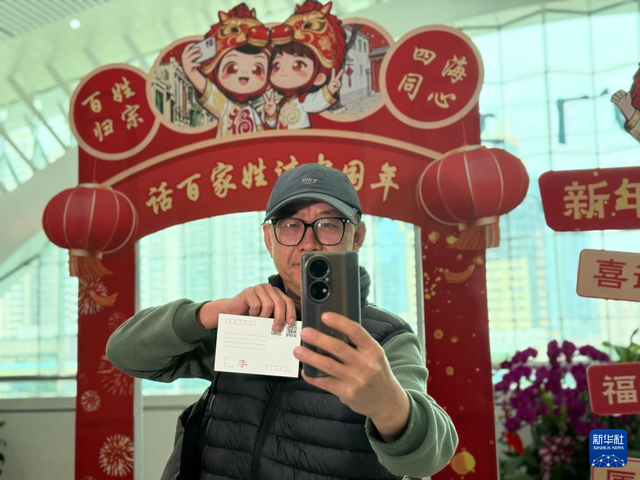 2月10日，在厦门站“话百家姓 过中国年”主题文化活动现场，台胞李高雄拿着专属姓氏明信片自拍留念。新华社记者 付敏 摄