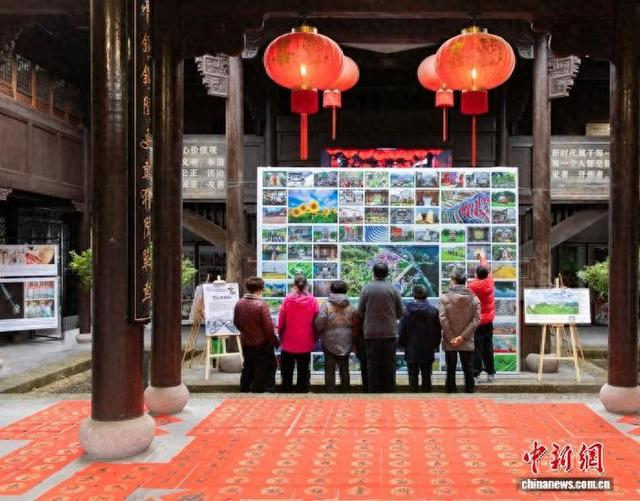 前路村村民欣赏摄影作品。 梅情斯 供图