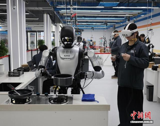2月5日，山东省济南市平阴县，数据采集员操作人形机器人在复刻的家庭厨房中完成物品递送与清洁。李明芮 摄