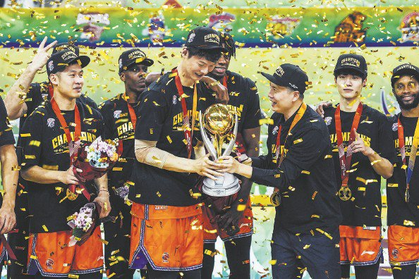             王哲林（中）手捧冠军奖杯  本报记者  李铭珅  摄          