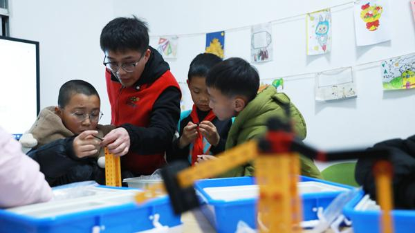 青年志愿者在“护苗学堂”带领孩子们进行兴趣拓展。王恩慧/摄