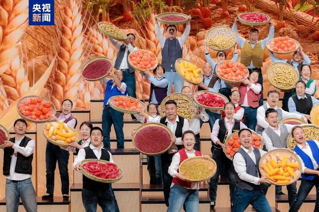 农民合唱团的乡亲们捧着沉甸甸的果实放声高歌。 图片来源：央视新闻