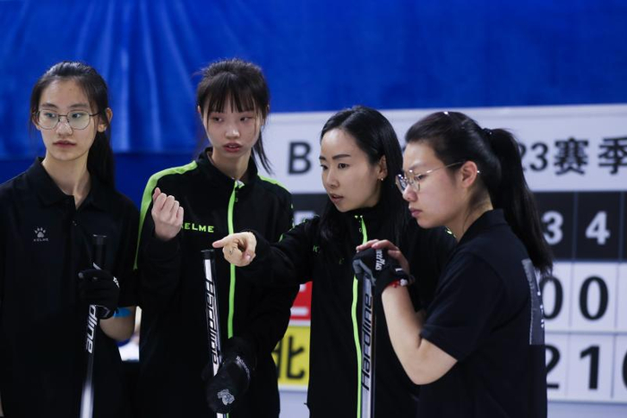 作为上海冰壶队教练，金智善（右二）在比赛间隙对队员进行指导（新华社）