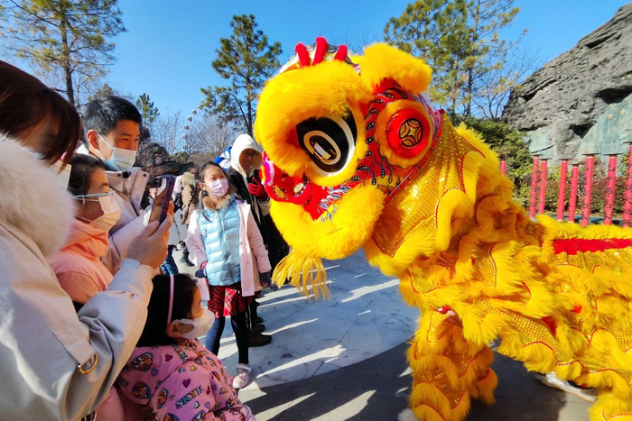 　　↑1月25日，游客在江苏常州淹城春秋乐园观看“祥狮送福”表演。新华社发（陈暐 摄）