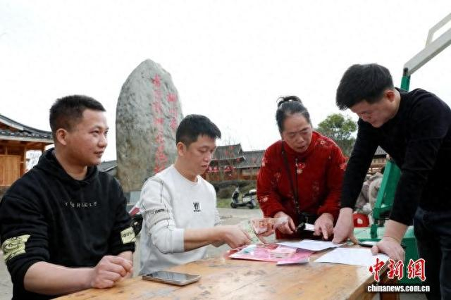 近日，在广西三江侗族自治县八江镇布央新村广场，村民在领取2025年集体经济收益分红。龚普康 摄