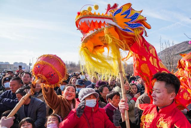 2月17日，在山东省邹平市奥体公园，黄山街道舞龙队员和群众亲密互动。新华社发（董乃德摄）