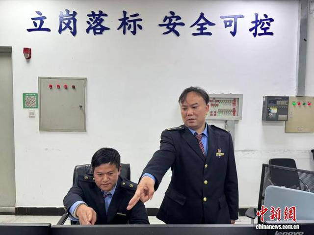 李朝辉与同事在工作中。国铁广州局 供图