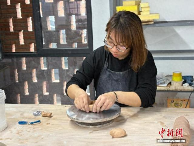 2月5日，台青苏萱瑄在景德镇陶溪川文创街区的工作室内正在创作陶艺作品。 中新社记者 李韵涵 摄