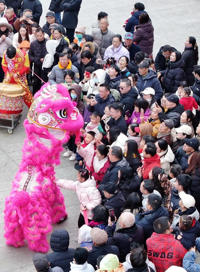 2月17日，在武汉市东湖梅园，民间艺人为游人表演《醒狮送财》（无人机照片）。新华社发（赵军摄）